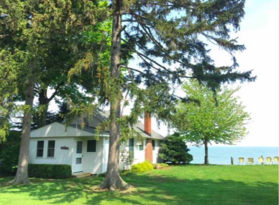 Picture of the outside of Cottage 9. View from the yard towards the cottage and lake.