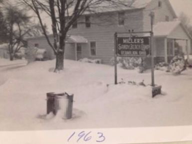 From cottage history: 1963 image of Stope 141/cottage office during a snow storm. Also in the picture, you can see the "Miller's Sandy Beach Sign".
