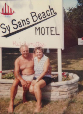 From cottage history: A picture of Frank and Helen Simon infront of the "Sy Sans Beach Motel" sign. They renamed the cottages after they purchased them in 1963 from the Millers.