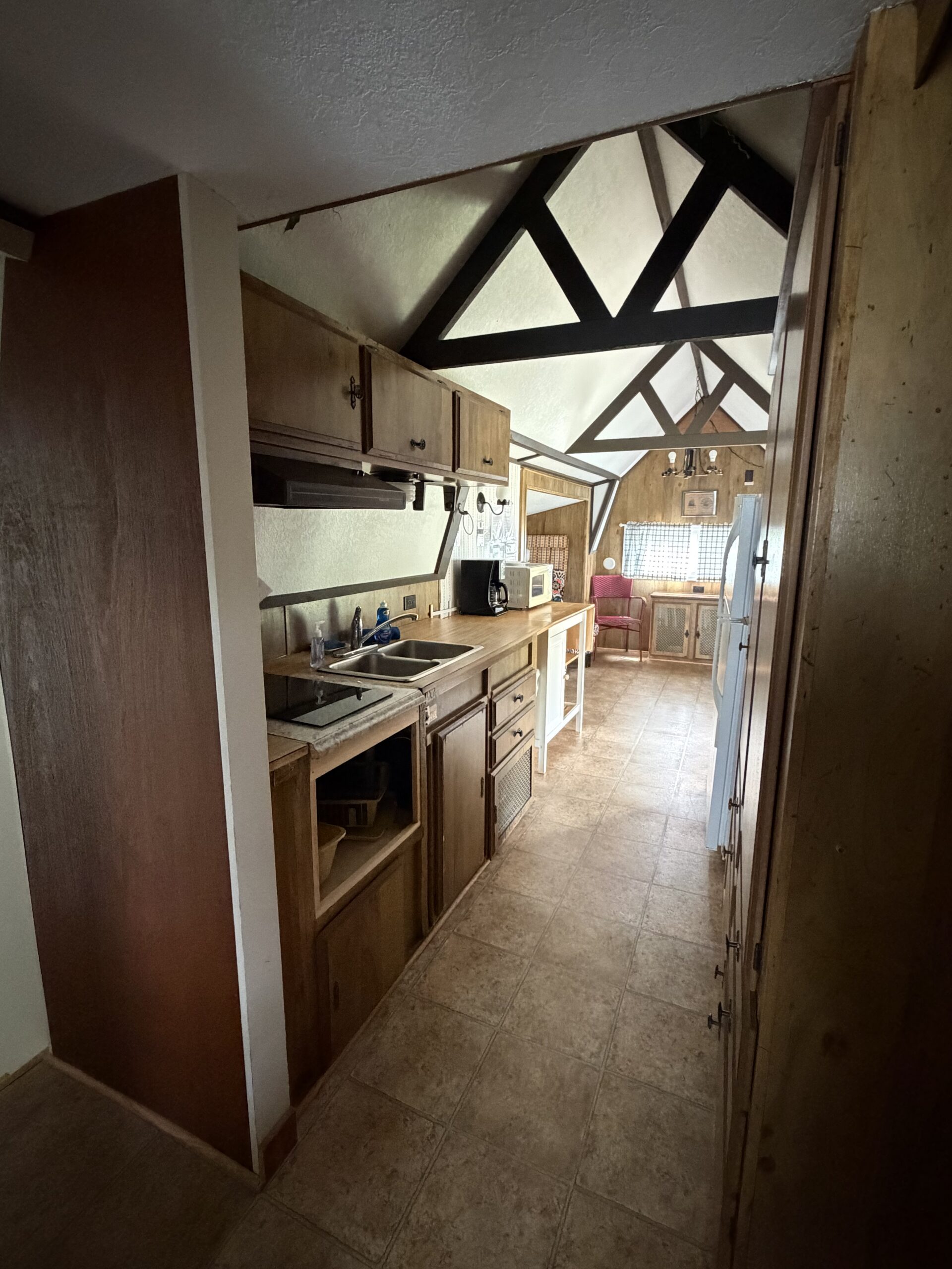 Cottage 10 galley kitchen with stove top, sink, microwave, toaster, coffee pot and refrigerator.